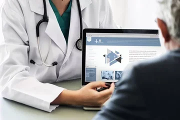 Doctor showing patient a patient portal website on laptop
