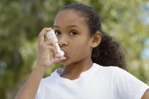 Young girl using an inhaler