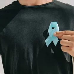 a man in a black shirt is holding a light blue ribbon symbolizing prostate cancer